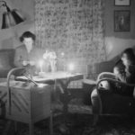 Woman and boy working by candlelight