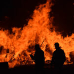Silhouetted figures in front of flames